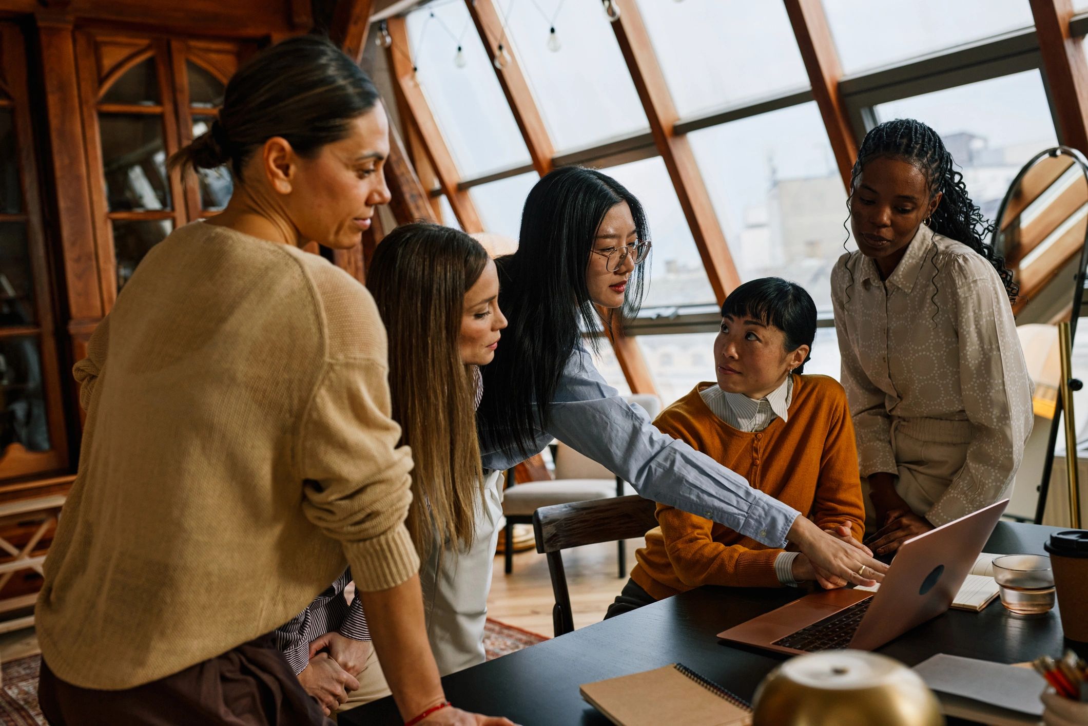 Consulting team collaborating around a laptop